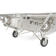 Fémből készült, részletgazdag, ezüstszínű Ford Trimotor repülőgép-modell állványon