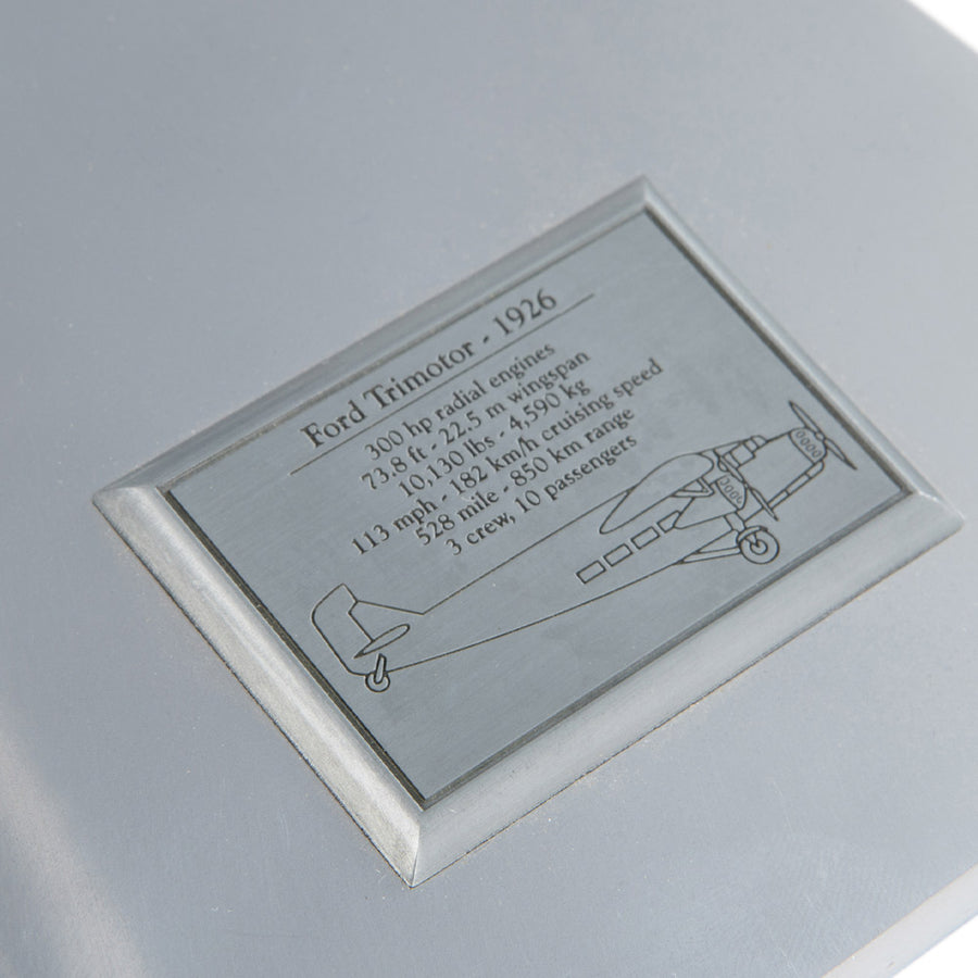 Fémből készült, részletgazdag, ezüstszínű Ford Trimotor repülőgép-modell állványon
