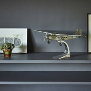 Fémből készült, részletgazdag, ezüstszínű Ford Trimotor repülőgép-modell állványon