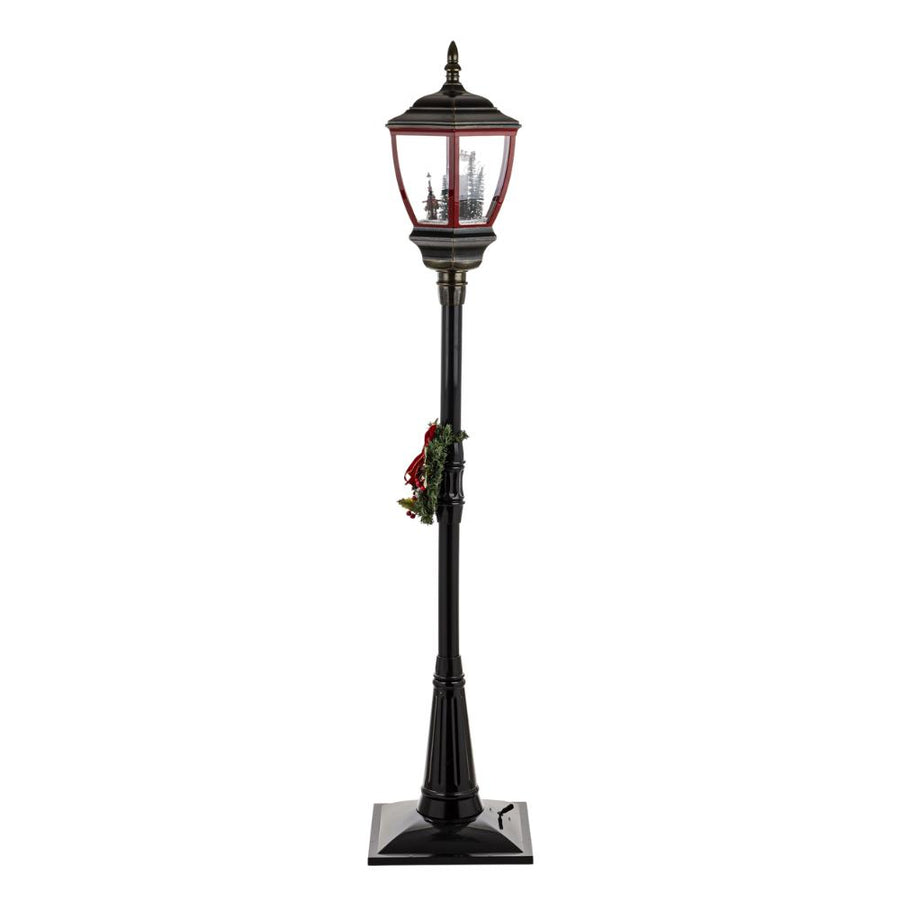 Karácsonyi állólámpa fehér háttér előtt – teljes magasság, látható a lámpásfej és a koszorú.