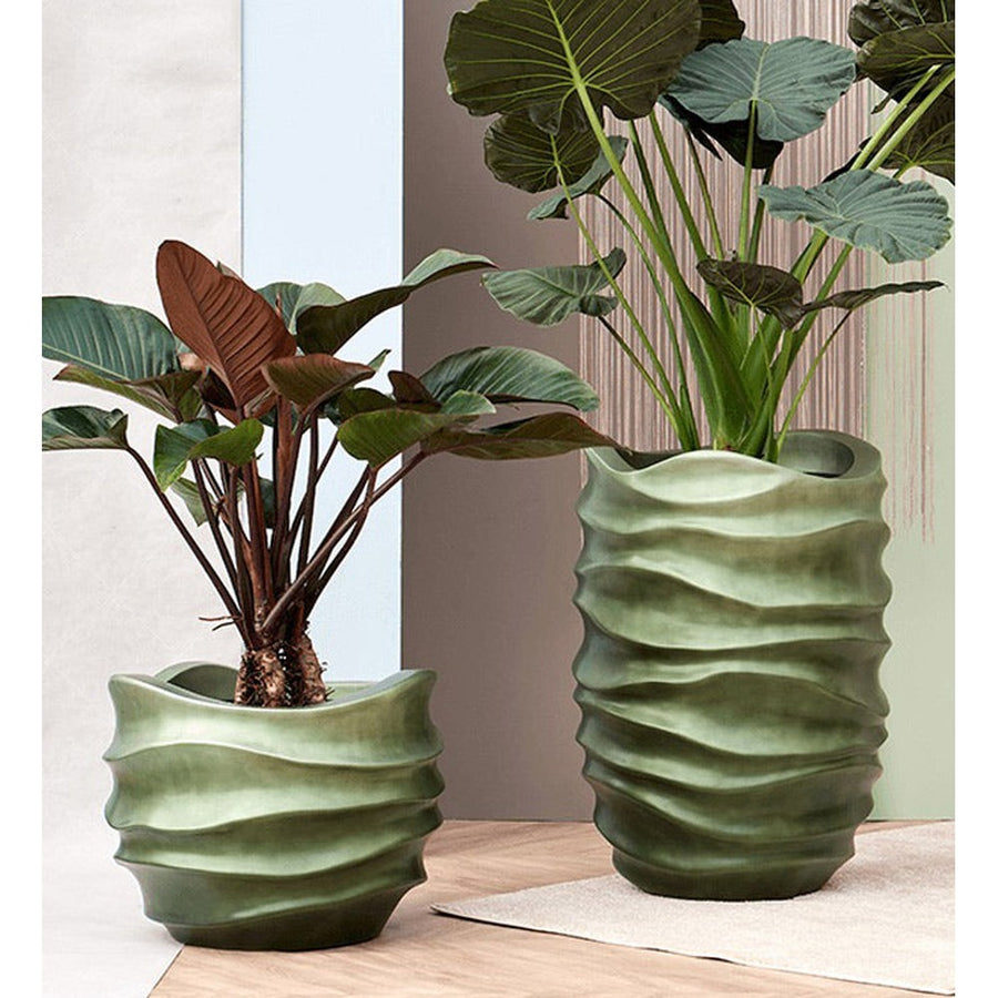 BAQ Gradient kaspók Forest Green színben, beltéri növényekkel – dekoratív, hullámos formájú design kaspók modern enteriőrben.