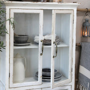 Krémszínű vitrines szekrény nyitott ajtóval edényekkel