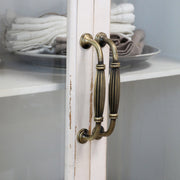 Régies fém fogantyú részlete krémszínű vitrines szekrényen