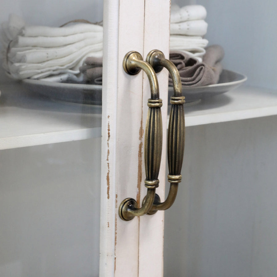 Régies fém fogantyú részlete krémszínű vitrines szekrényen