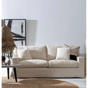 Törzsi stílusú nappaliban, dohányzóasztal mögött álló bézs színű kanapé.