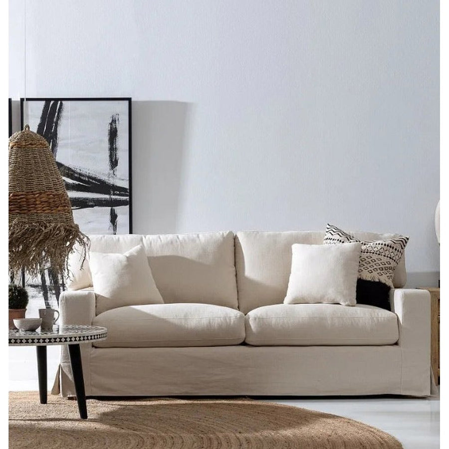 Törzsi stílusú nappaliban, dohányzóasztal mögött álló bézs színű kanapé.