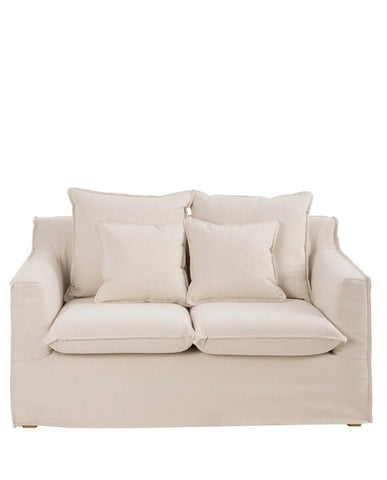 Bézs színű pamutvászon kárpitozású, kényelmes párnákkal ellátott kortárs kanapé..