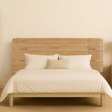 Natúr színű teakfa Eyre ágyvég, világos bézs ágyneművel minimalista hálószobai környezetben.