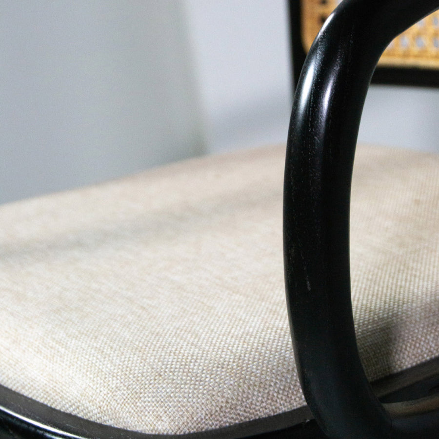 Koloniál stílusú, fekete színű, teakfa étkezőszék rattan háttámlával és bézs ülőfelülettel.