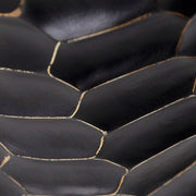 Kortárs stílusú, surafából készült kisasztal markáns faragású, fekete színű lábának részlete.