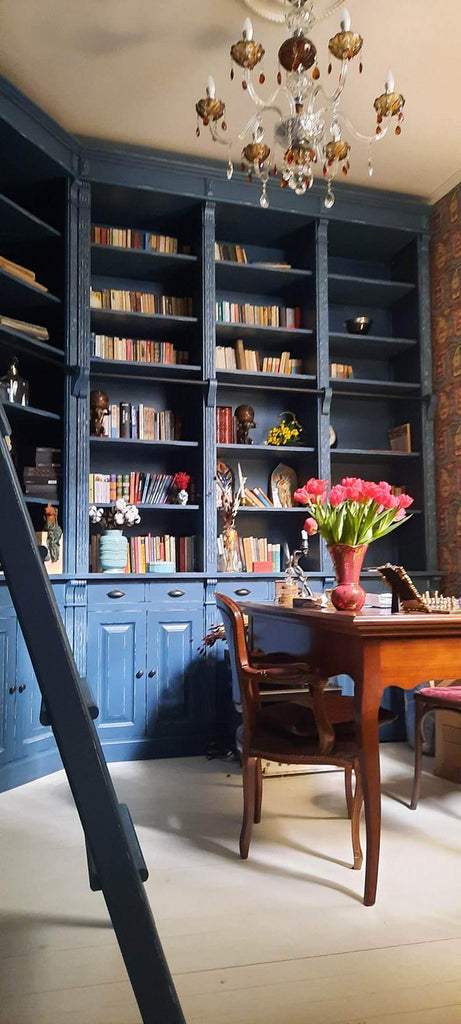 Egyedi tervezésű, antikolt kék színű könyvszekrény-fal, ívelt falu dolgozó szobában.