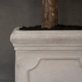 Heritage matt taupe fiberstone kaspó profilozott felső peremének, klasszikus keretezett díszítésének és kőhatású felületének részlete.