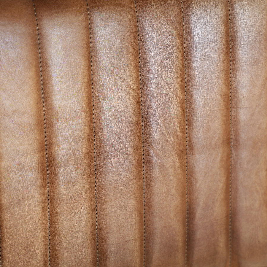 Loft stílusú, hajlított fémcső szerkezetű, barna színű bőrrel kárpitozott szék.