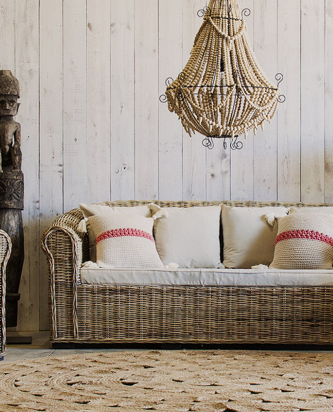 Mediterrán stílusú, 3 személyes rattan kanapé törtfehér színű párnákkal.