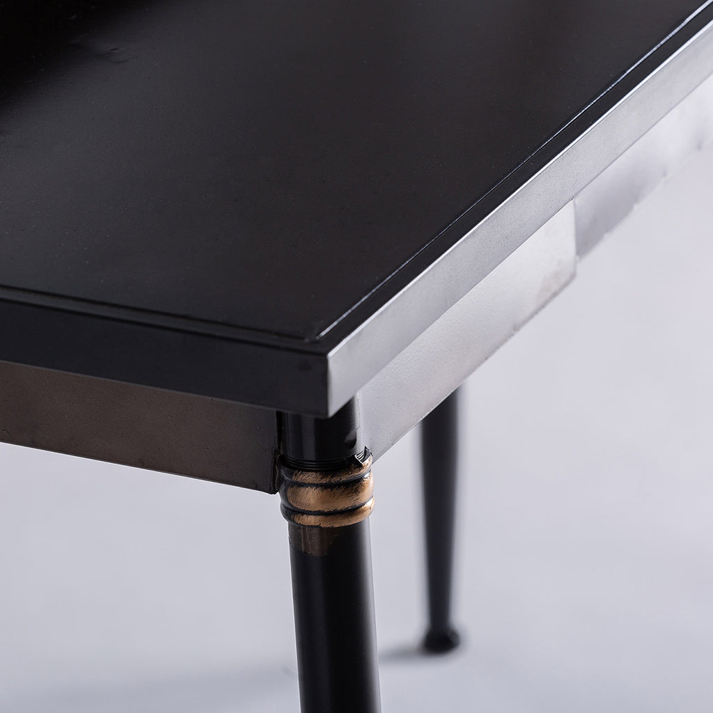 A loft stílusú, fém íróasztal asztallapjának és lábának részlete.