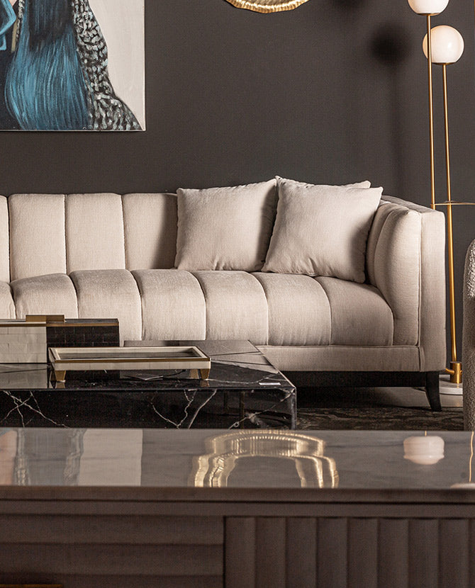 Csokoládébarna színű, art deko stílusú nappaliban álló törtfehér színű kanapé.