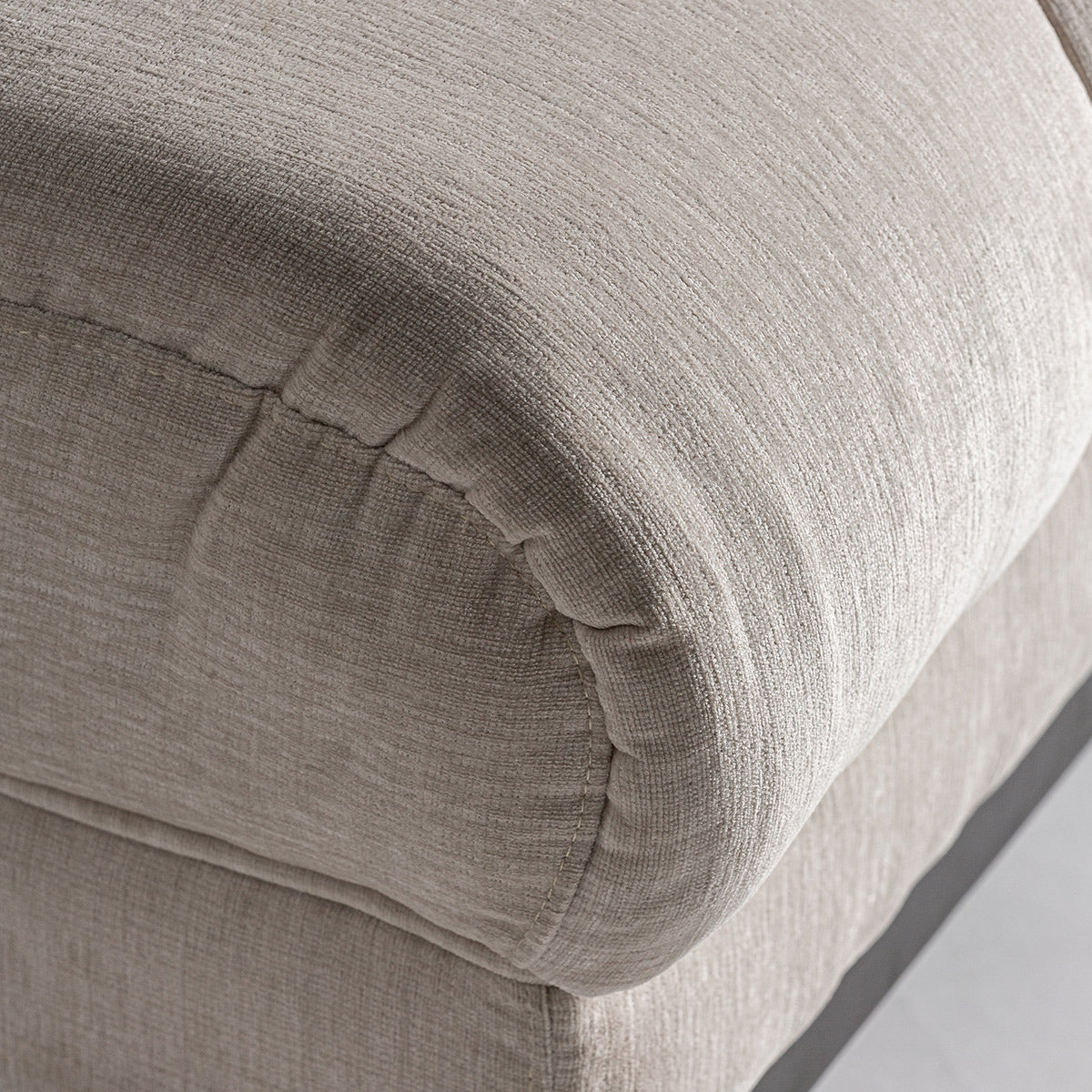 A kortárs stílusú, törtfehér színű kanapé ülőfelület részlete.