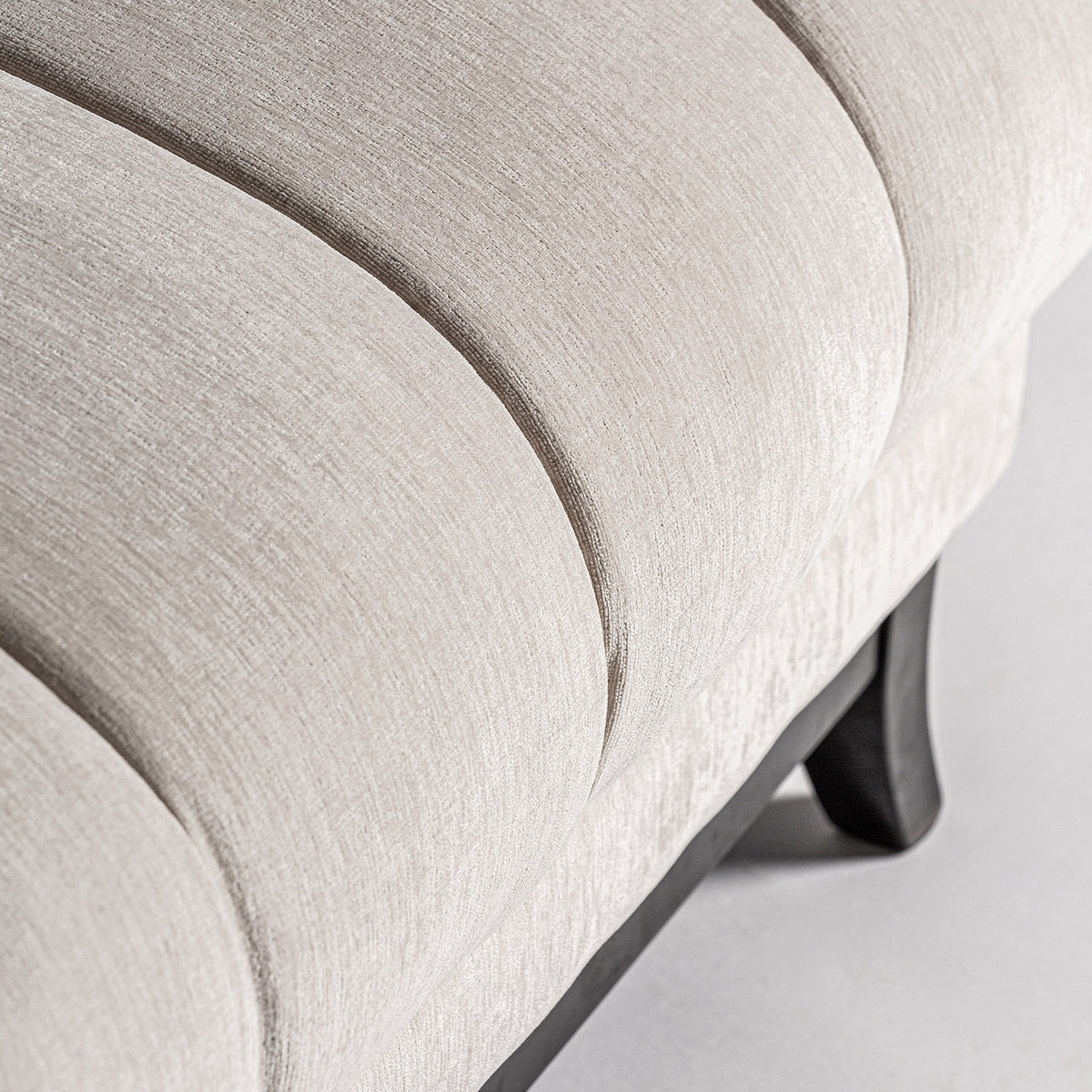 A kortárs stílusú, törtfehér színű kanapé ülőfelület részlete.