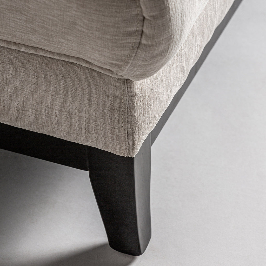 A kortárs stílusú, törtfehér színű kanapé láb részlete.