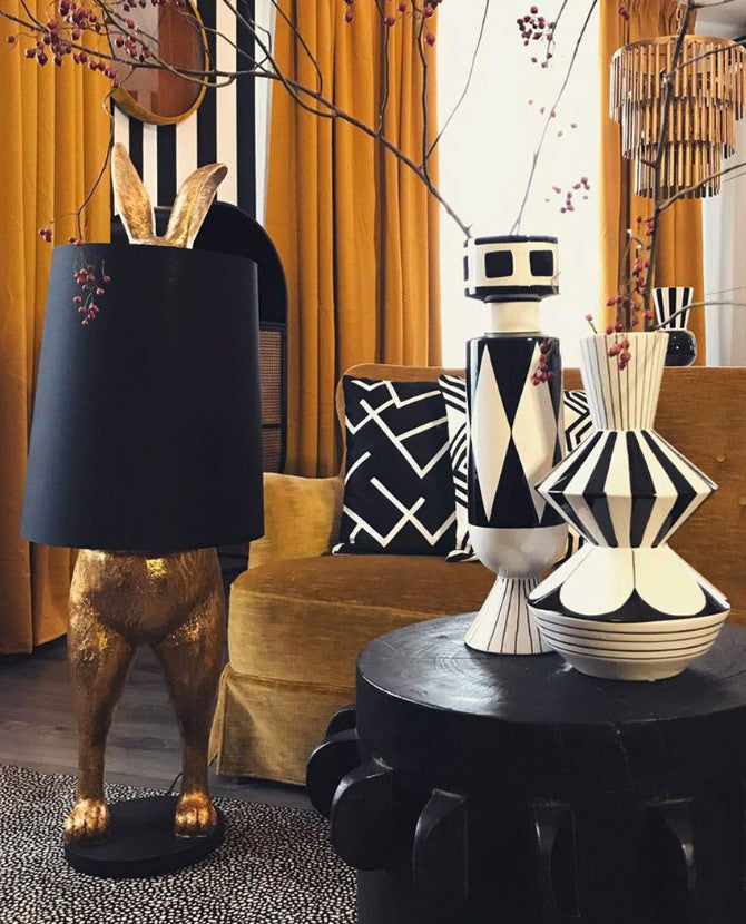 Aranyszínű, rejtőzködő nyuszi figurás, díjnyertes dizájn állólámpa, feketeszínű lámpaernyővel.