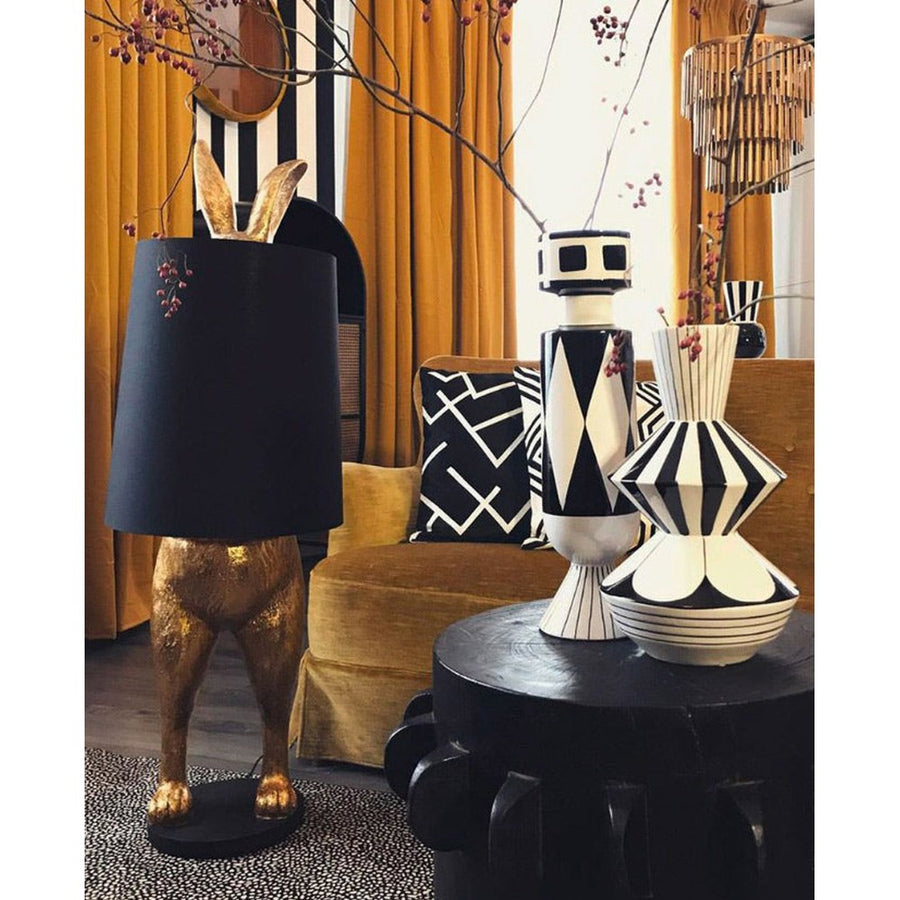 Aranyszínű, rejtőzködő nyuszi figurás, díjnyertes dizájn állólámpa, feketeszínű lámpaernyővel.