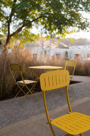 Yvonne sárga színű fém bútorgarnitúra tóparti sétányon