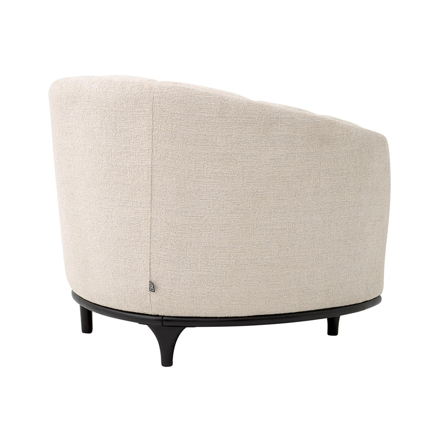 Bézs színű szövettel kárpitozott dizájn fotel.