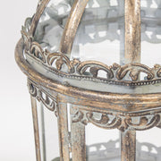 Díszes, ornamentikával gazdagon kialakított aranyszínű fém lámpás felső keretének közeli képe