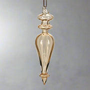 Hosszúkás, kézzel fújt, megcsavart formájú borostyánsárga üveg jégcsap dísz, fényes felülettel.