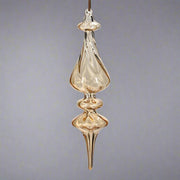 Hosszúkás, kézzel fújt, megcsavart formájú borostyánsárga üveg jégcsap dísz, fényes felülettel.