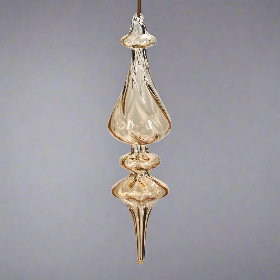 Hosszúkás, kézzel fújt, megcsavart formájú borostyánsárga üveg jégcsap dísz, fényes felülettel.