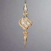 Modern, mégis klasszikus megjelenésű borostyánsárga üveg karácsonyfadísz, elegáns csavart formában.