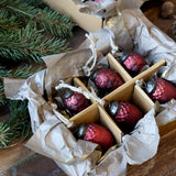 Antik meggybordó üvegdísz szettek közelről, toboz és makk mintázatú díszekkel