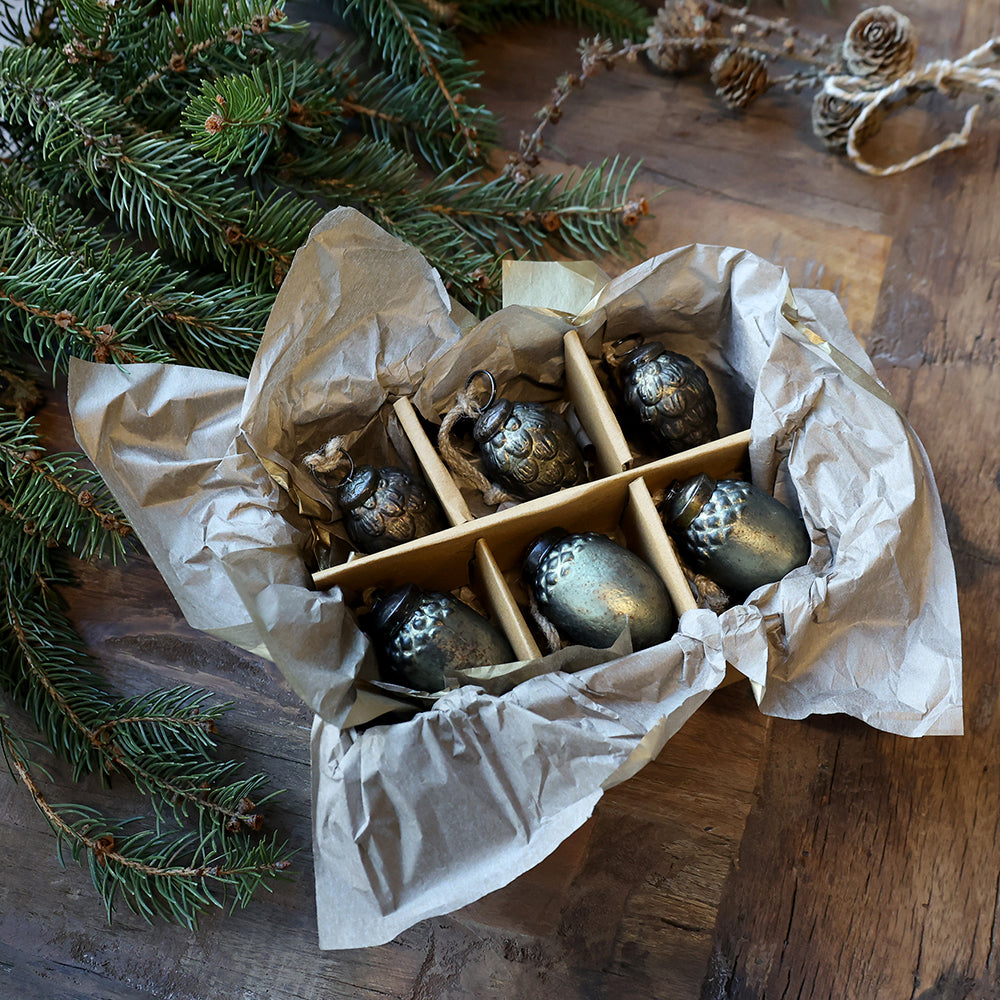 Vintage stílusú antik olívazöld karácsonyfadíszek díszdobozban, rusztikus papírral és fenyőágakkal