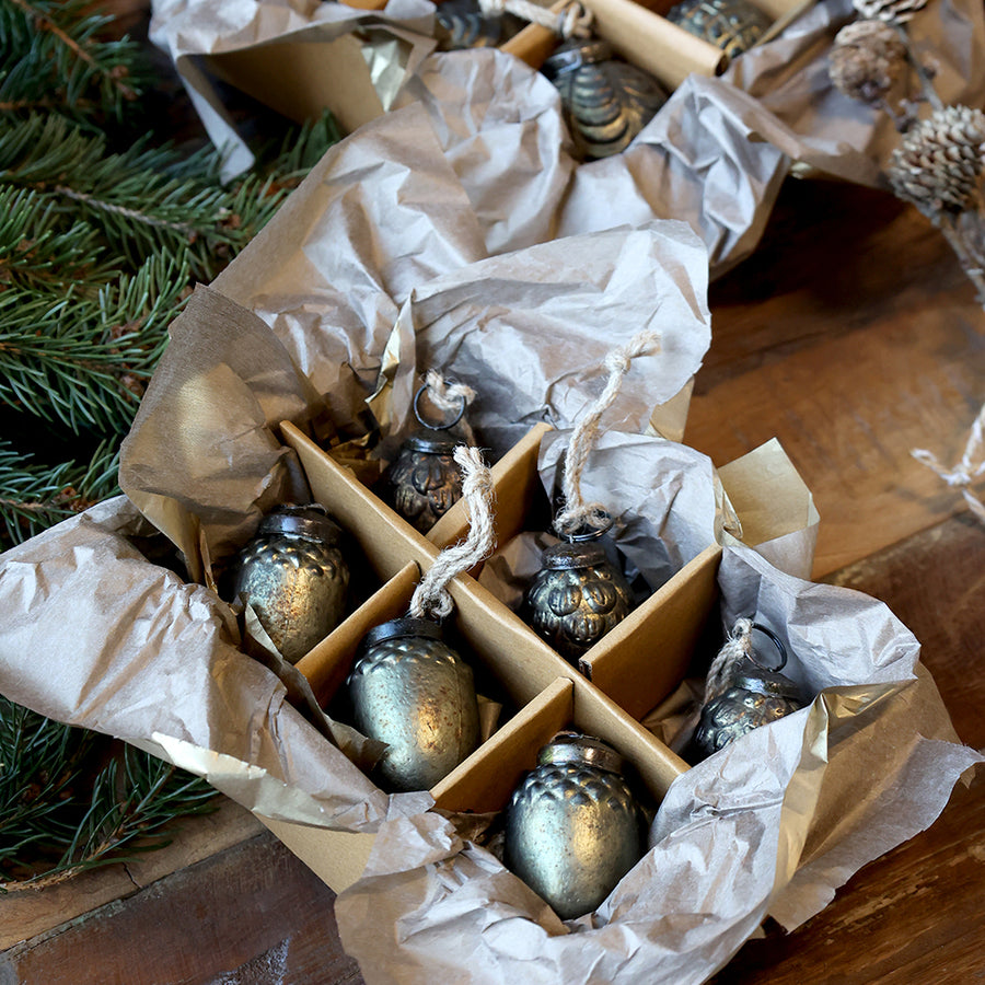 Antik olívazöld üvegdísz szettek közelről, toboz és makk mintázatú díszekkel