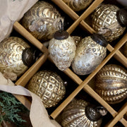 Az Antique makk- és tobozformájú üveg karácsonyfadíszek patinás mintázata és juta akasztói közelről.