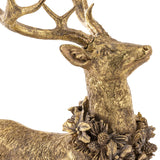 Arany színű szarvas szobor részletfotó, ünnepi koszorúval