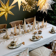 Klasszikus arany-krém karácsonyi dekoráció gyertyákkal és fenyőkkel