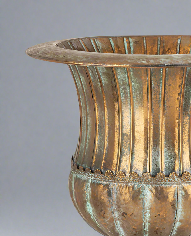 Antique Metals kaspó részletgazdag díszítéssel és patinázott rézszínű felülettel, klasszikus urnás forma közelről.