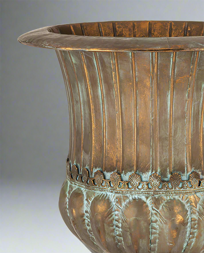 Antique Metals kaspó részletgazdag díszítéssel és patinázott rézszínű felülettel, klasszikus urnás forma közelről.
