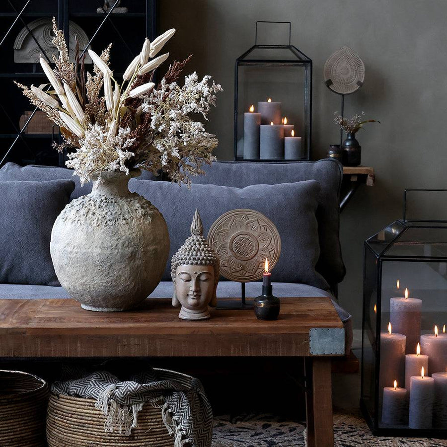 Nagy méretű antik váza bohém nappali hangulatban, gyertyákkal és Buddha szoborral