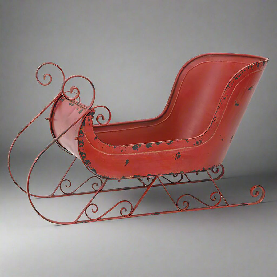 Teljes nézetű fém szán dekoráció stúdiókörnyezetben, antik bordó színben, klasszikus formákkal.