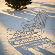 Óriás fém karácsonyi dekor szán havas környezetben.