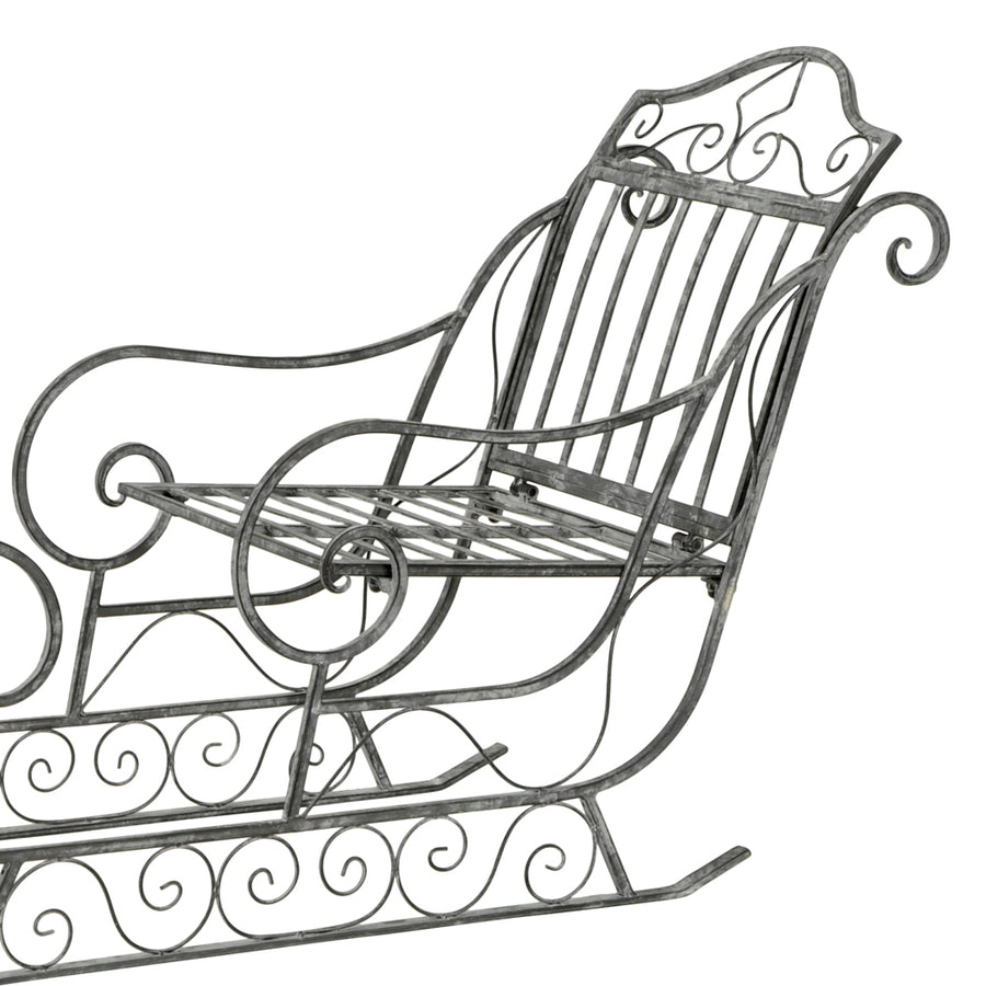 Dekoratív karácsonyi szán fém ülőfelülete és ívelt háttámlája, klasszikus vidéki stílusban.