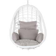Aurora Nest fehér műrattan kerti függőfotel bézs színű párnákkal, szemből fotózva, fehér háttér előtt.