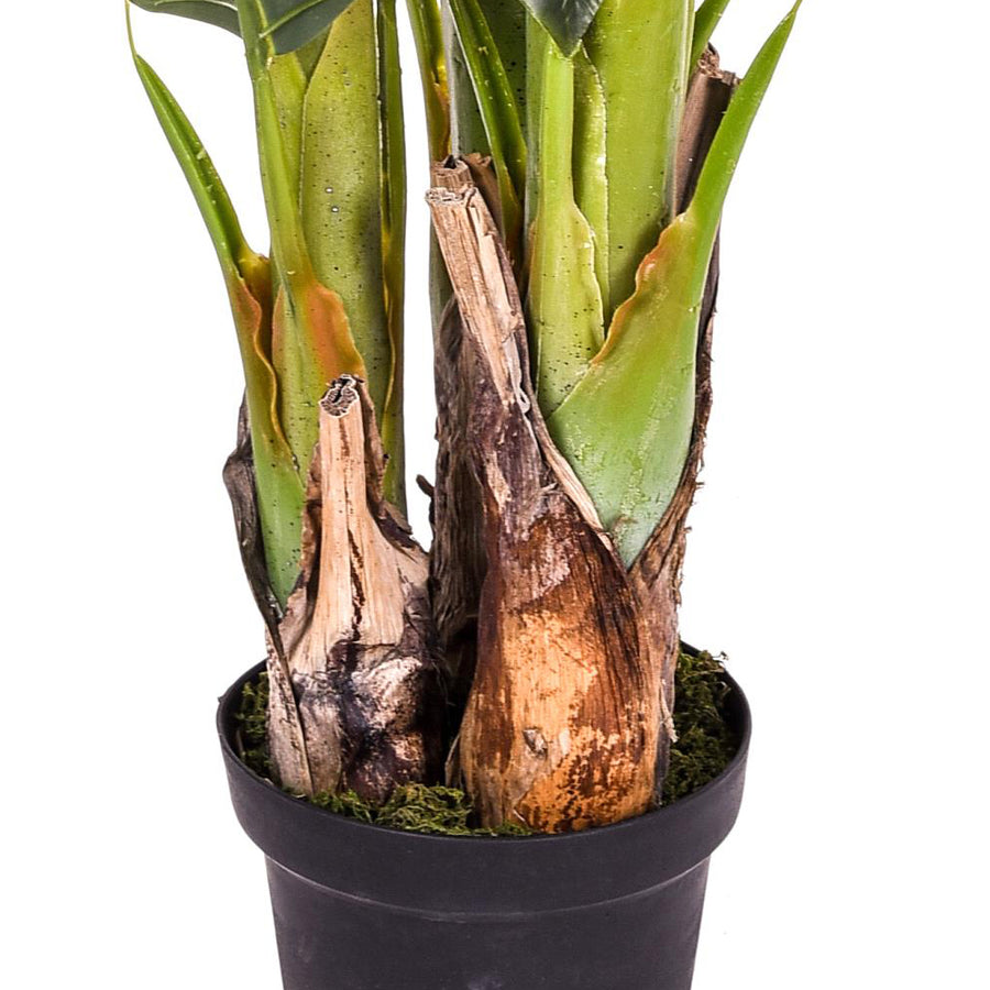 A mű banánfa alsó törzsrésze, természetes hatású fakéreg mintázattal és fekete kaspóval.