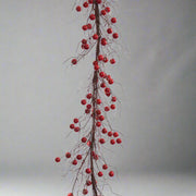 Fényes bordópiros bogyók és barnás szárak rusztikus hatással.