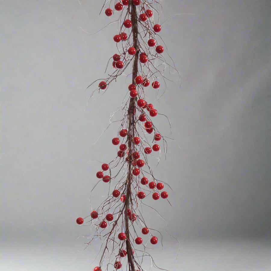 Fényes bordópiros bogyók és barnás szárak rusztikus hatással.