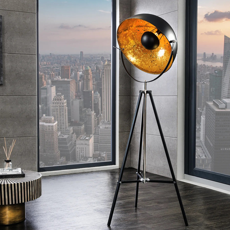 Háromlábú, aranyszínű design állólámpa.