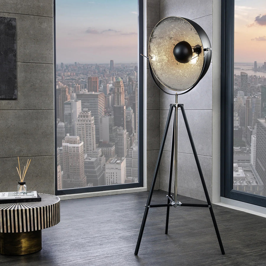 Háromlábú, ezüstszínű design állólámpa.